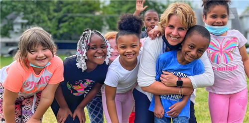 Perry teacher posing in group shot with students outdoors.